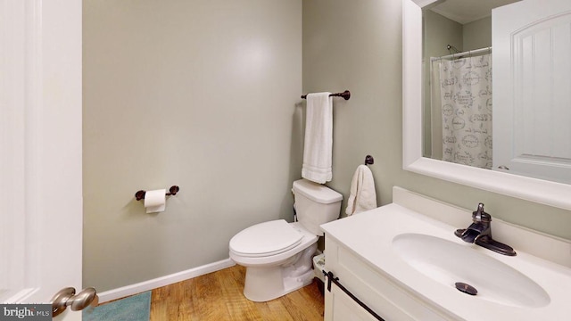 bathroom featuring vanity, a shower with curtain, wood finished floors, baseboards, and toilet