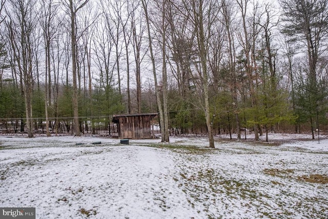 yard covered in snow with a forest view