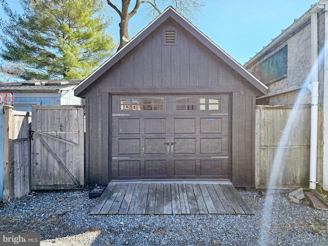 detached garage with a gate and fence