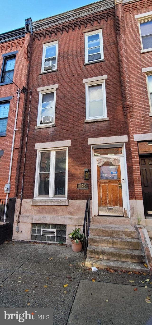 townhome / multi-family property featuring brick siding and cooling unit