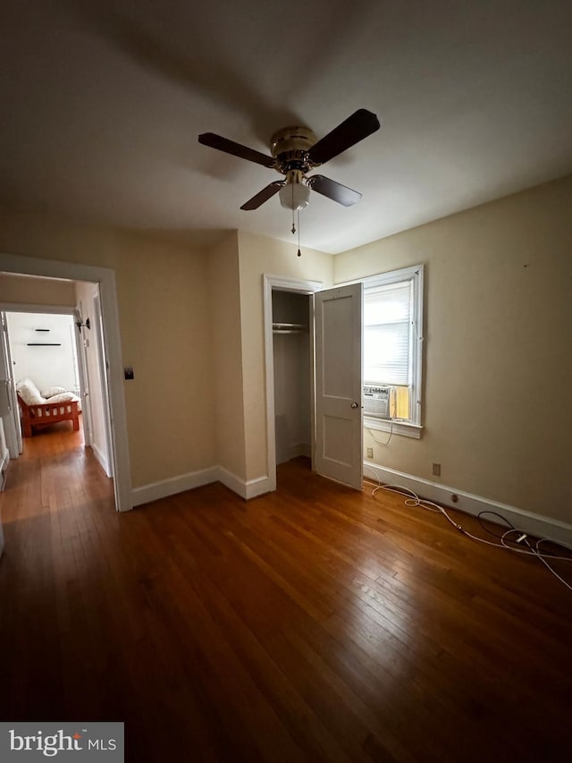 unfurnished bedroom featuring hardwood / wood-style floors, baseboards, a closet, and ceiling fan