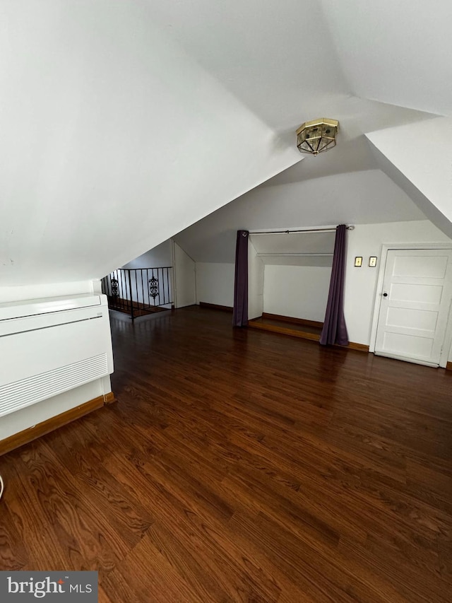 additional living space featuring lofted ceiling and wood finished floors