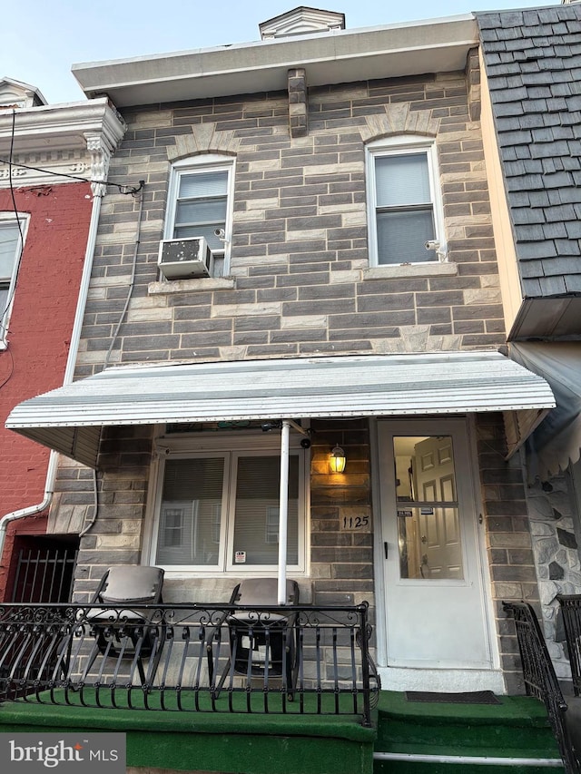 entrance to property with stone siding and cooling unit