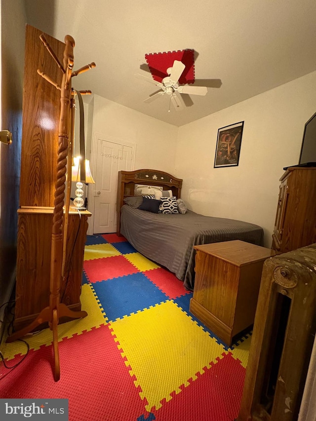 carpeted bedroom with a ceiling fan and vaulted ceiling