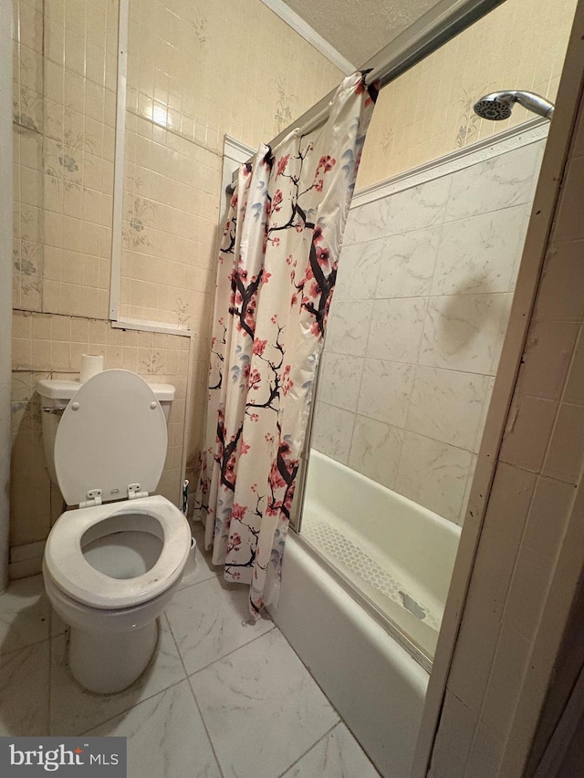 bathroom with tile walls, toilet, marble finish floor, and shower / bath combo