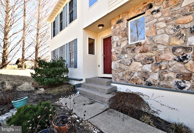 property entrance featuring stone siding and stucco siding