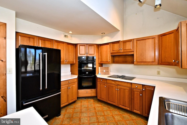 kitchen with a sink, visible vents, black appliances, and brown cabinetry