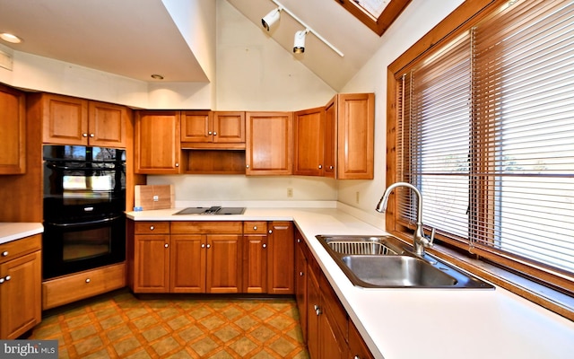 kitchen featuring black appliances, brown cabinets, tile patterned floors, and a sink