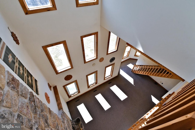 unfurnished living room with a skylight and a towering ceiling