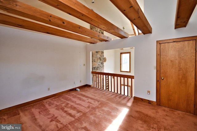 carpeted spare room featuring beamed ceiling and baseboards