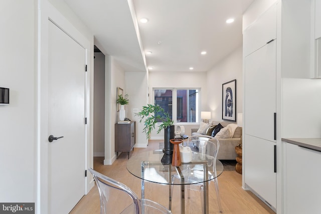 dining space with recessed lighting, light wood-type flooring, and baseboards