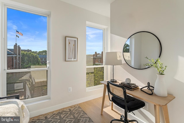 office area featuring a wealth of natural light, baseboards, and wood finished floors