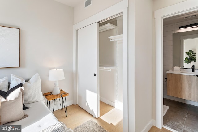 bedroom featuring visible vents, baseboards, and wood finished floors