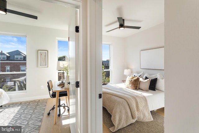 bedroom with ceiling fan, baseboards, and wood finished floors