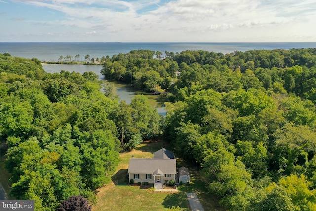 drone / aerial view with a forest view and a water view