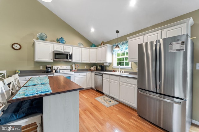 kitchen featuring appliances with stainless steel finishes, white cabinetry, light wood-type flooring, and a sink