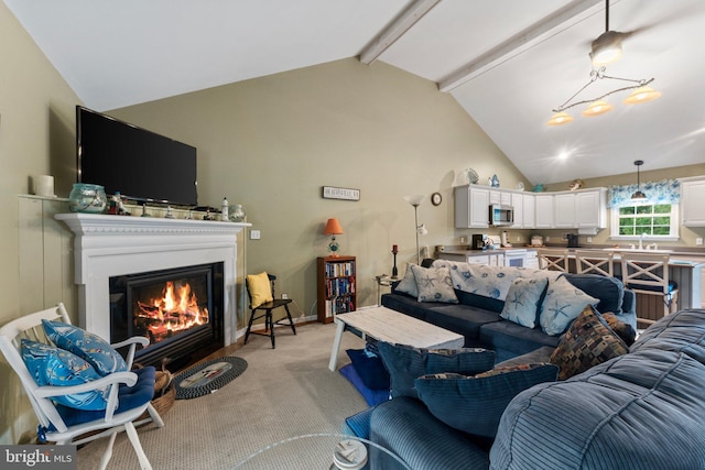 living room with light colored carpet, a warm lit fireplace, vaulted ceiling with beams, and baseboards