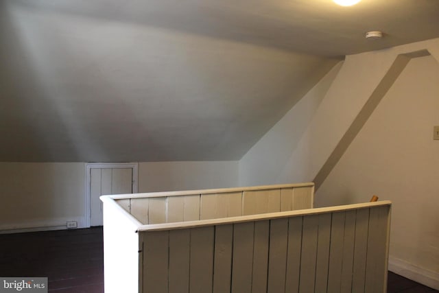 bonus room featuring dark wood-style floors and vaulted ceiling