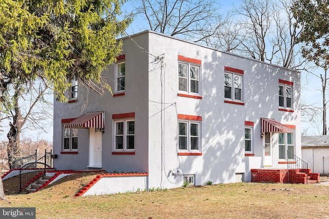 view of front of home with a front lawn and stucco siding