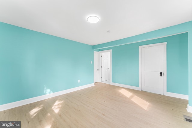 unfurnished bedroom featuring visible vents, baseboards, and wood finished floors