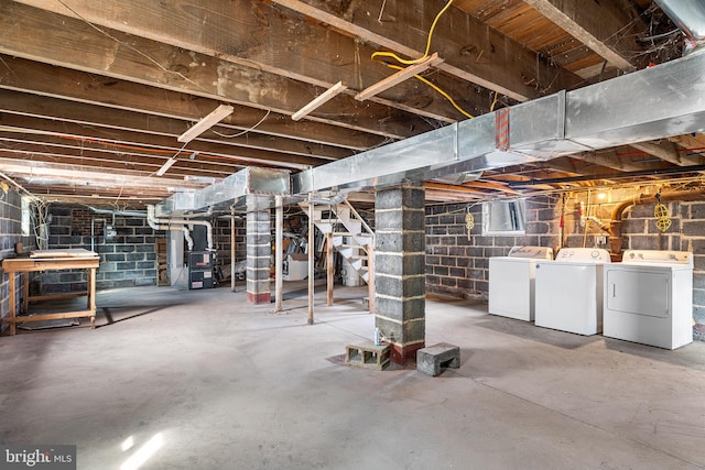 unfinished below grade area with stairs and washer and clothes dryer