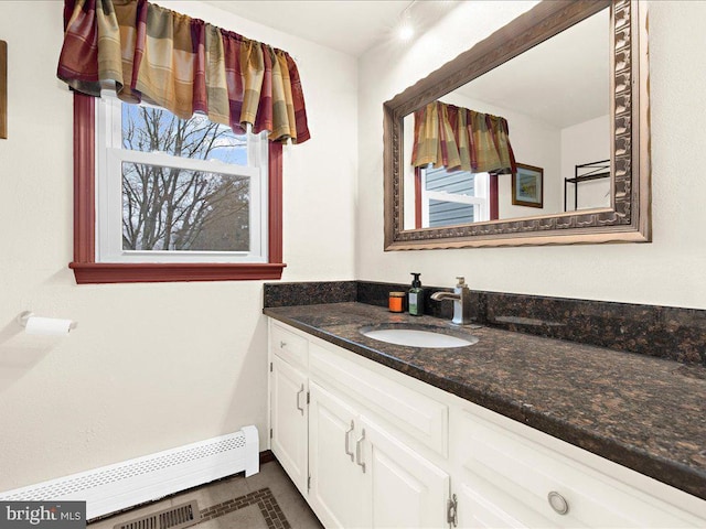 bathroom featuring vanity, visible vents, baseboards, and a baseboard radiator