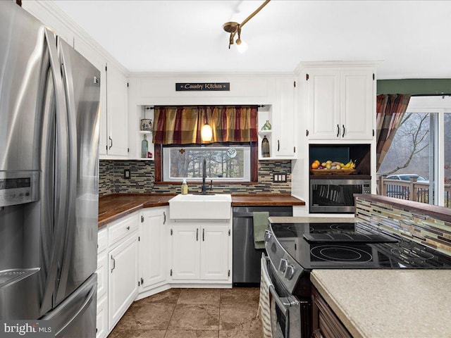 kitchen featuring decorative backsplash, appliances with stainless steel finishes, open shelves, and a sink