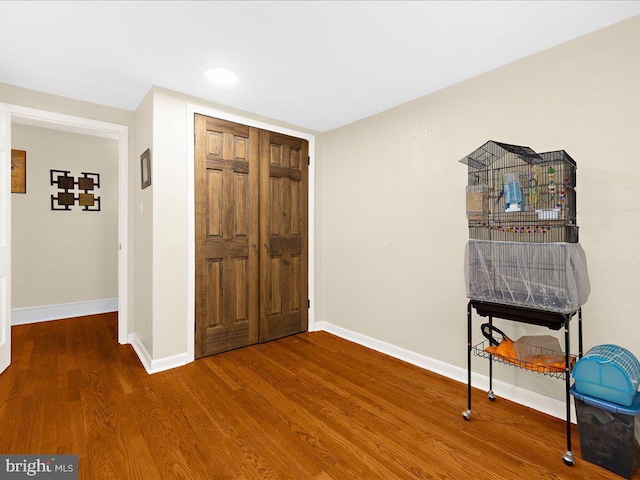 bedroom with a closet, recessed lighting, baseboards, and wood finished floors