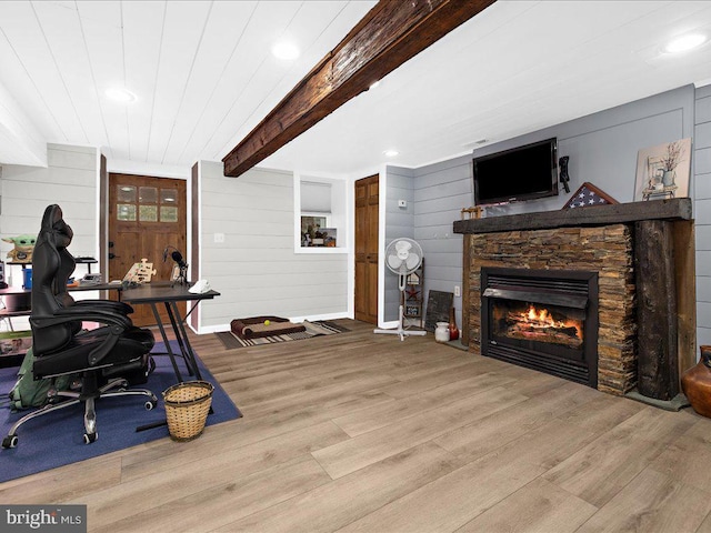 office area with beam ceiling, wooden walls, wood finished floors, and a fireplace