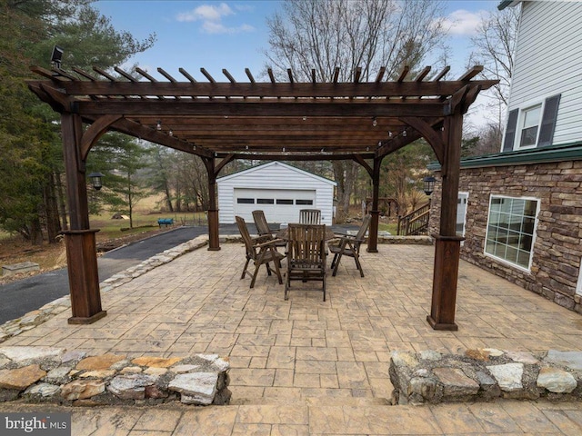 view of patio / terrace featuring a garage, an outdoor structure, outdoor dining area, and a pergola