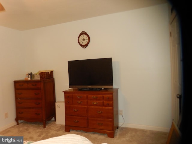 bedroom with baseboards and light carpet