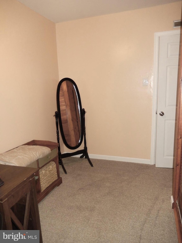 living area with visible vents, baseboards, and carpet