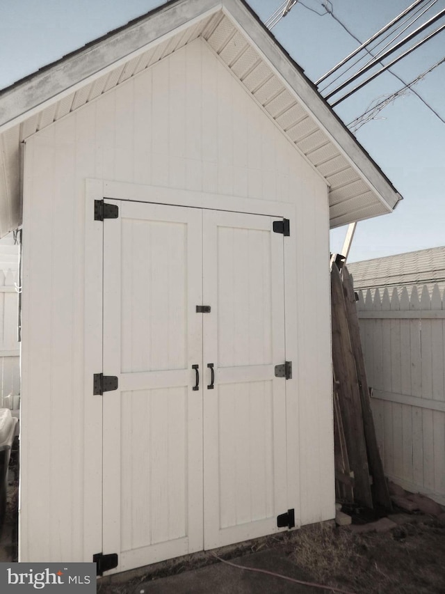 view of shed featuring fence