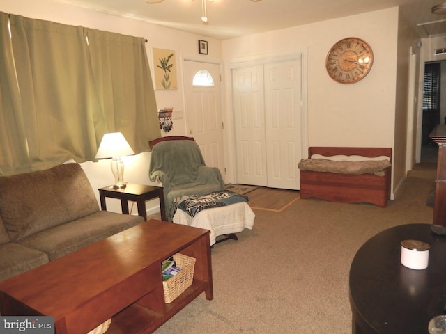 carpeted living area featuring a ceiling fan