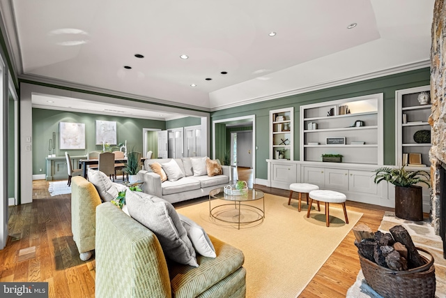 living room with crown molding, wood finished floors, baseboards, visible vents, and recessed lighting