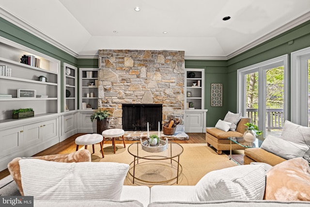 living room featuring vaulted ceiling, built in features, and wood finished floors