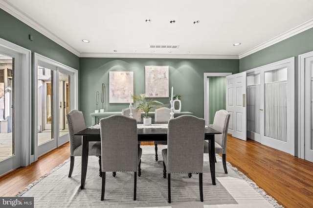 dining room featuring crown molding, light wood-style floors, visible vents, and recessed lighting