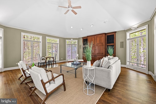 living area featuring vaulted ceiling, ornamental molding, dark wood-type flooring, and baseboards