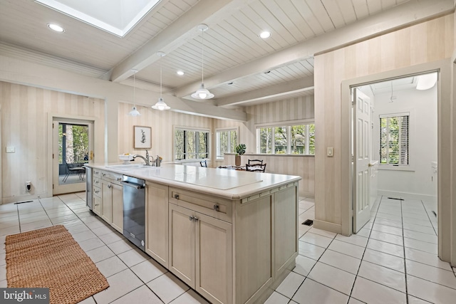 kitchen featuring light countertops, dishwasher, a sink, light tile patterned floors, and beam ceiling