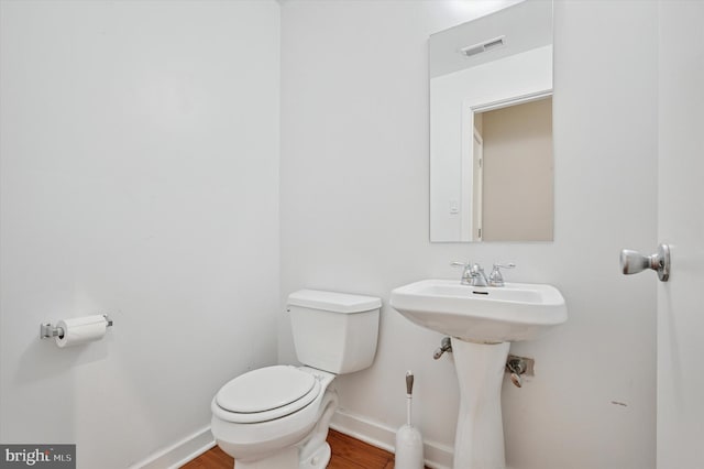 bathroom featuring visible vents, baseboards, toilet, and wood finished floors