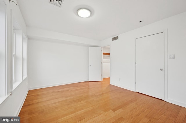 unfurnished bedroom with baseboards, visible vents, and light wood finished floors