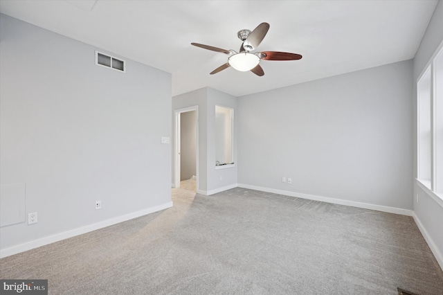 empty room featuring ceiling fan, carpet, visible vents, and baseboards