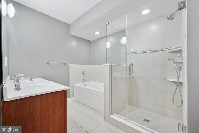 bathroom featuring vanity, a garden tub, a shower stall, and tile patterned flooring