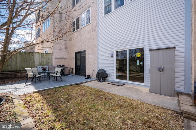 back of property featuring a patio and fence