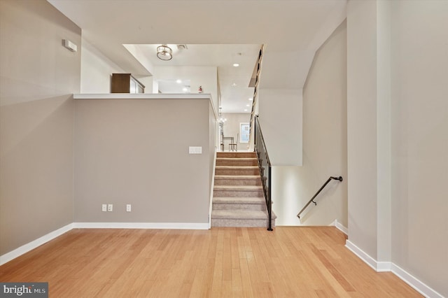 stairs with wood finished floors and baseboards