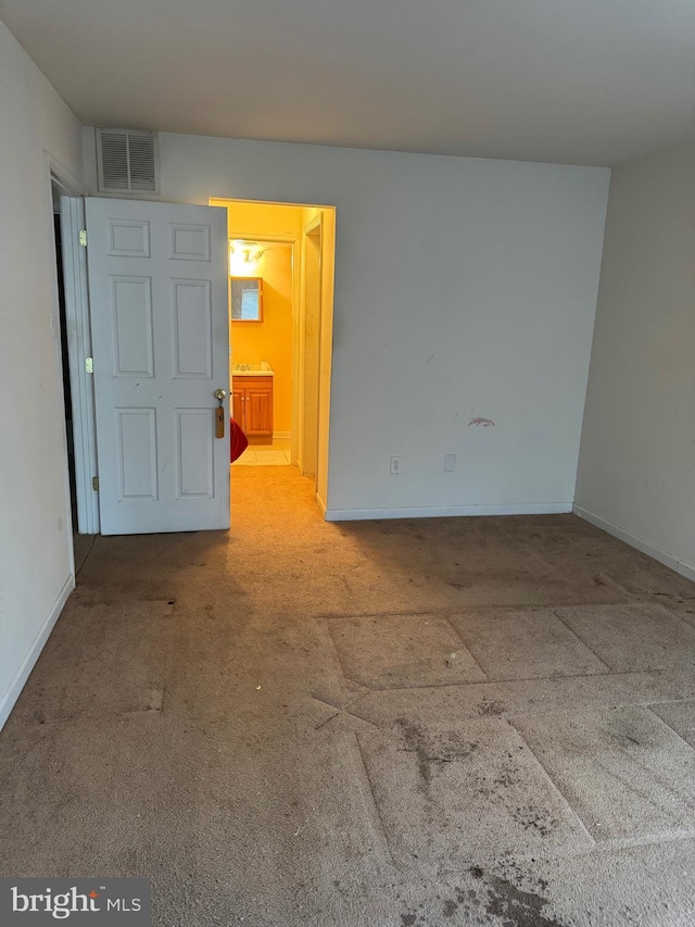 carpeted empty room featuring baseboards and visible vents