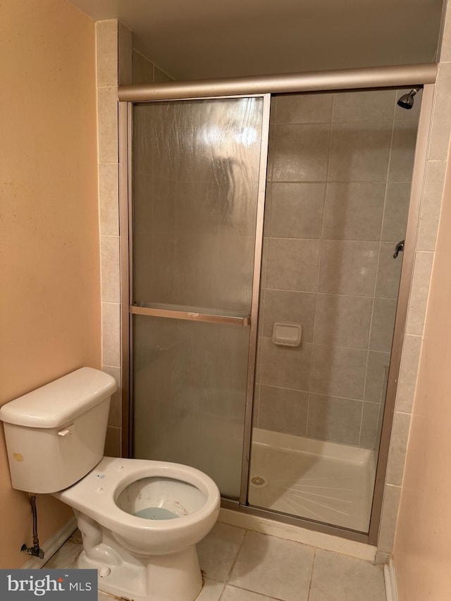 full bathroom with tile patterned floors, a shower stall, and toilet