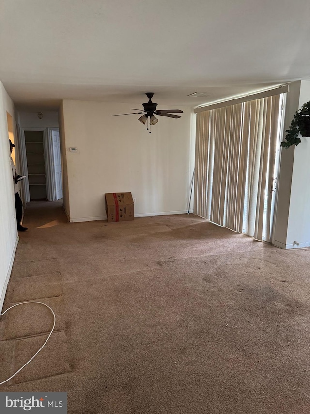 unfurnished living room with a ceiling fan and carpet