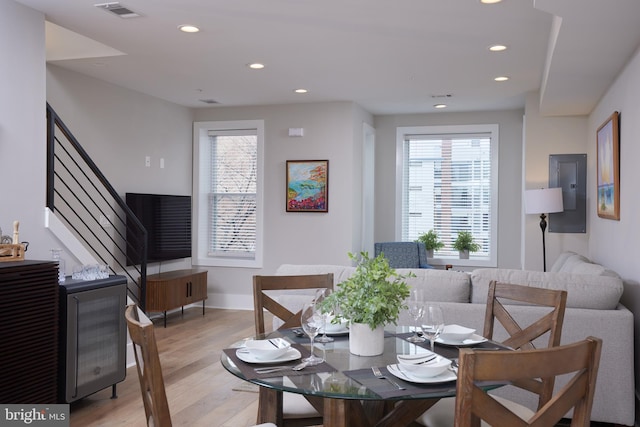 dining area featuring light wood finished floors, visible vents, stairway, electric panel, and recessed lighting