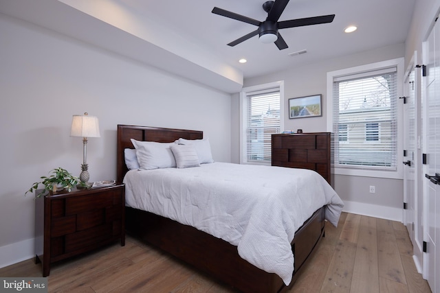 bedroom with visible vents, baseboards, hardwood / wood-style floors, recessed lighting, and a ceiling fan